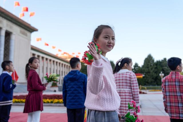 A girl waves before a welcoming ceremony for Germany’s President Frank-Walter Steinmeier outside the Great Hall of the People in Beijing on October 30, 2026. (Photo by Kai Naito / POOL / AFP)