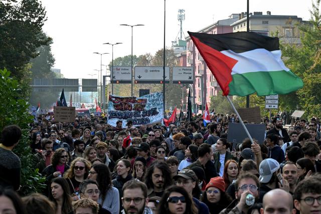 Protesters wave a Palestinian flag during a demonstration part of a nationwide day of strikes and protests as school and university students demand more funding for schools and support for housing, in Milan, northern Italy on October 30, 2026. Students have been protesting for weeks, setting up tent camps and occupying schools to make their demands heard, matching similar movements across the border in France. The Italian protests have taken place alongside those of truck drivers and farmers over the spike in fuel prices and the cost of living, as well as rising defence spending. (Photo by Stefano RELLANDINI / AFP)