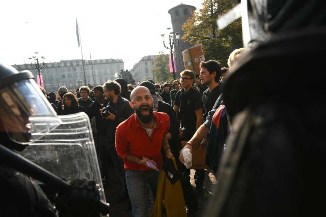 Protesters faces Italian police officers during a demonstration part of a nationwide day of strikes and protests as school and university students demand more funding for schools and support for housing, inTurin on October 30, 2026. Students have been protesting for weeks, setting up tent camps and occupying schools to make their demands heard, matching similar movements across the border in France. The Italian protests have taken place alongside those of truck drivers and farmers over the spike in fuel prices and the cost of living, as well as rising defence spending. (Photo by Marco BERTORELLO / AFP)