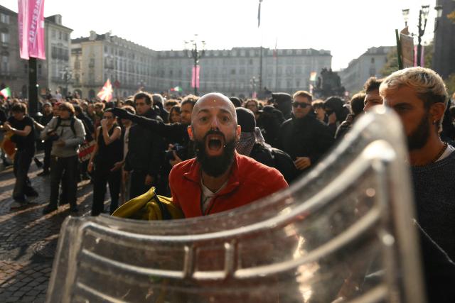 A protester yells at anti riot officers during a demonstration part of a nationwide day of strikes and protests as school and university students demand more funding for schools and support for housing, inTurin on October 30, 2026. Students have been protesting for weeks, setting up tent camps and occupying schools to make their demands heard, matching similar movements across the border in France. The Italian protests have taken place alongside those of truck drivers and farmers over the spike in fuel prices and the cost of living, as well as rising defence spending. (Photo by Marco BERTORELLO / AFP)