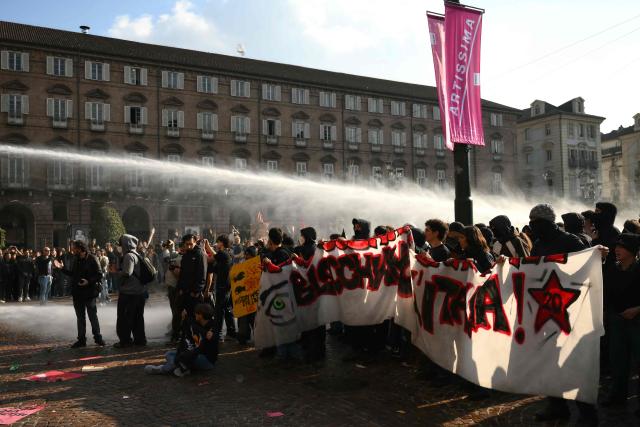 Protesters face a water cannon during a demonstration part of a nationwide day of strikes and protests as school and university students demand more funding for schools and support for housing, inTurin on October 30, 2026. Students have been protesting for weeks, setting up tent camps and occupying schools to make their demands heard, matching similar movements across the border in France. The Italian protests have taken place alongside those of truck drivers and farmers over the spike in fuel prices and the cost of living, as well as rising defence spending. (Photo by Marco BERTORELLO / AFP)