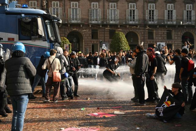 Protesters face a water cannon during a demonstration part of a nationwide day of strikes and protests as school and university students demand more funding for schools and support for housing, inTurin on October 30, 2026. Students have been protesting for weeks, setting up tent camps and occupying schools to make their demands heard, matching similar movements across the border in France. The Italian protests have taken place alongside those of truck drivers and farmers over the spike in fuel prices and the cost of living, as well as rising defence spending. (Photo by Marco BERTORELLO / AFP)