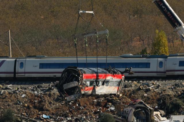 A huge crane lifts one of the wrecked carriages of a train crash between a Renfe AVE train and an Iryo train, two days after the deadly accident in Urda, in the province of Toledo on October 30, 2026. A high-speed train collision south of Madrid killed 69 people and injured scores more on October 28, 2026 authorities said, in one of Europe's deadliest such disasters this century. The second such accident to strike Spain this year will raise fresh questions about the country's rail safety, with the transport minister speaking of an "error" and "inexplicable circumstances" that led to the crash. (Photo by Oscar DEL POZO / AFP)