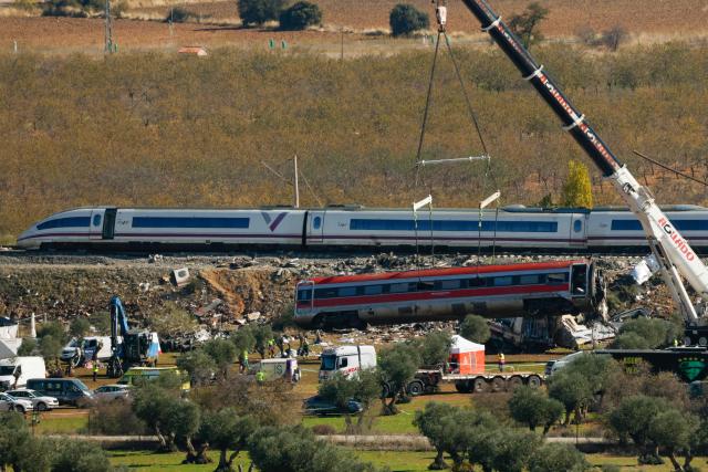 A huge crane lifts one of the wrecked carriages of a train crash between a Renfe AVE train and an Iryo train, two days after the deadly accident in Urda, in the province of Toledo on October 30, 2026. A high-speed train collision south of Madrid killed 69 people and injured scores more on October 28, 2026 authorities said, in one of Europe's deadliest such disasters this century. The second such accident to strike Spain this year will raise fresh questions about the country's rail safety, with the transport minister speaking of an "error" and "inexplicable circumstances" that led to the crash. (Photo by Oscar DEL POZO / AFP)