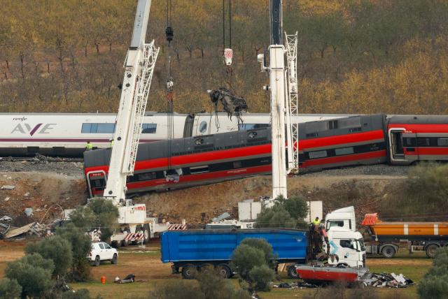 A huge crane lifts one of the wrecked carriages of a train crash between a Renfe AVE train and an Iryo train, two days after the deadly accident in Urda, in the province of Toledo on October 30, 2026. A high-speed train collision south of Madrid killed 69 people and injured scores more on October 28, 2026 authorities said, in one of Europe's deadliest such disasters this century. The second such accident to strike Spain this year will raise fresh questions about the country's rail safety, with the transport minister speaking of an "error" and "inexplicable circumstances" that led to the crash. (Photo by Oscar DEL POZO / AFP)