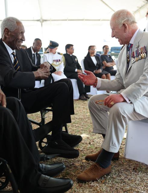 King Charles III (R) meets with World War II and pre-independence veterans at the Commonwealth War Graves in Georgetown on October 30, 2026. King Charles III is on an official visit to Guyana. (Photo by Chris Jackson / POOL / AFP)