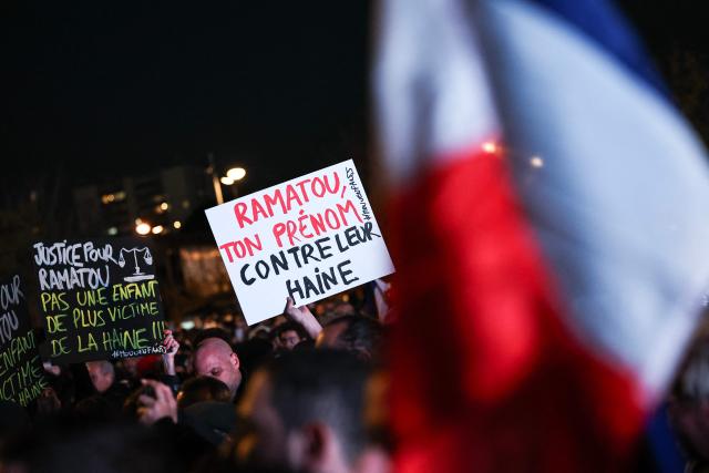 Attendees hold placards reading "Ramatou, your name against hatred" and "
justice for Ramatou", with reference to the  the 11-year-old girl who was seriously injured in the racist attack that took place in the Yvelines region, during a rally against racism and to pay tribute to the victims of the attack, in Trappes on October 30, 2026.. A man arrested after a gun attack, which took place on October 23, 2026 in the towns of Trappes and La Verriere, west of Paris, killing one person and wounding seven including a child, has admitted to "targeting individuals who appeared to be Muslim, African, or North African," prosecutors said on October 29, 2026. (Photo by SIMON WOHLFAHRT / AFP)