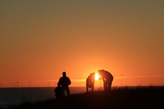 People take pictures of the sunset in La Gueriniere, on Noirmoutier island, western France on October 30, 2026. (Photo by Ludovic MARIN / AFP)