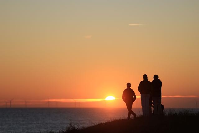 People look at the sunset in La Gueriniere, on Noirmoutier island, western France on October 30, 2026. (Photo by Ludovic MARIN / AFP)