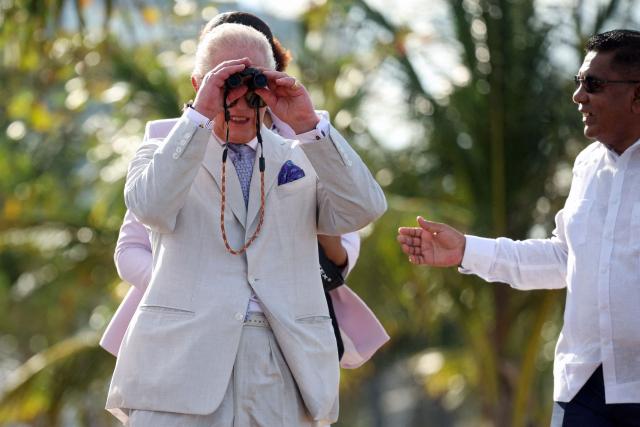 Britain's King Charles III (L) uses binoculars alongside Mangrove Restoration and Management Project Coordinator Kene Moseley at the Kingston Seawall in Georgetown on October 30, 2026. King Charles III is on an official visit to Guyana. (Photo by Isabel Infantes / POOL / AFP)