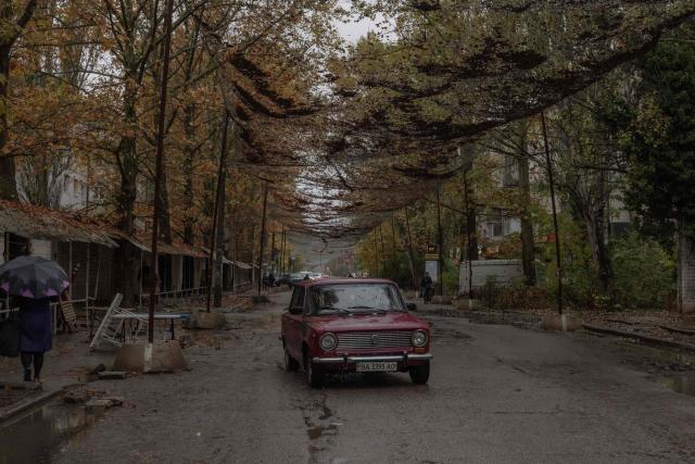 This photograph shows a car droven on a road covered with anti-drone nets during a temporary ceasefire in the southern Kherson region in the city of Kherson, southern Ukraine, on October 30, 2026, amid the Russian invasion of Ukraine. The respite from a fragile ceasefire in Oleshky, a Russian-occupied town in southern Ukraine ravaged by food and medicine shortages, to pave the way for evacuations and humanitarian aid deliveries and due to end on November 1 evening, has also given residents in the major southern Ukrainian city of Kherson relief from daily drone attacks. The truce has held despite unabated attacks elsewhere in Ukraine. (Photo by Roman PILIPEY / AFP)