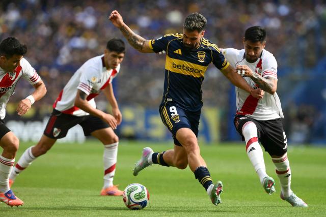 (FILES) Boca Juniors' forward #09 Milton Gimenez (C) and River Plate's midfielder #05 Juan Portillo (R) fight for the ball during the Argentine Professional Football League 2025 Clausura Tournament match between Boca Juniors and River Plate at the La Bombonera Stadium in Buenos Aires on November 9, 2025. Boca Juniors and River Plate, Argentina's two most popular clubs, will face off on November 1st, 2026, at La Bombonera in the latest edition of the Superclásico, a matchup that could prove decisive in the race for the Clausura tournament title. (Photo by Luis ROBAYO / AFP)