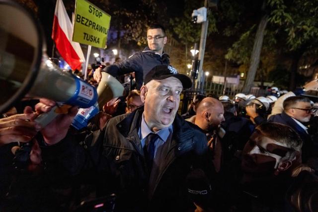 Constitutional court president Bogdan Swieczkowski speaks with protesters gathered outside the headquarters of the Poland's Constitutional Court in Warsaw after police blocked access to the court building on October 30, 2026. (Photo by Wojtek RADWANSKI / AFP)