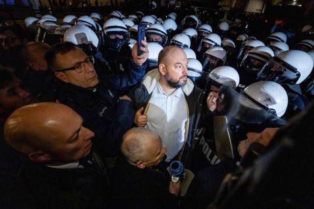 Poland's former Prime Minister and leader of the opposition Law and Justice (PiS) party, Jaroslaw Kaczynski (C), confronts police officers as protesters gather outside the headquarters of Poland's Constitutional Court in Warsaw after police blocked access to the building on October 30, 2026. Poland's President Karol Nawrocki called off a visit to Africa in mid-flight as riot police deployed around the country's constitutional court on October 30 following the suspension of its chief justice in a battle between the centrist government and the nationalist right. Dozens of police guarded the entrance to the court as followers of the opposition right-wing Law and Justice party (PiS) protested the ousting of constitutional court president Bogdan Swieczkowski. (Photo by Wojtek RADWANSKI / AFP)