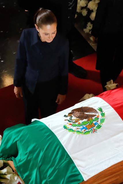 Mexico's President Claudia Sheinbaum stands beside the coffin of former Mexican presidential candidate Cuauhtemoc Cardenas, who died on October 28 at the age of 92, during a tribute ceremony at the Palace of Fine Arts in Mexico City on October 30, 2026. Hundreds of Mexicans, including President Claudia Sheinbaum, paid tribute to Cuauhtemoc Cardenas, a three-time presidential candidate, former Mexico City mayor and leading figure of Mexico's modern left, during a memorial service held at the Palace of Fine Arts. (Photo by Barny GOMEZ / AFP)