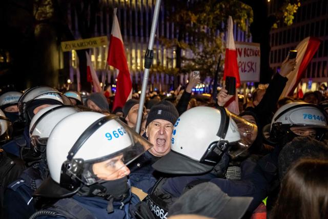 A man shouts slogans during police intervention as protesters gather outside the headquarters of the Poland's Constitutional Court in Warsaw after police blocked access to the court building on October 31, 2026. Poland's President Karol Nawrocki called off a visit to Africa in mid-flight as riot police deployed around the country's constitutional court on October 30 following the suspension of its chief justice in a battle between the centrist government and the nationalist right. Dozens of police guarded the entrance to the court as followers of the opposition right-wing Law and Justice party (PiS) protested the ousting of constitutional court president Bogdan Swieczkowski. (Photo by Wojtek RADWANSKI / AFP)