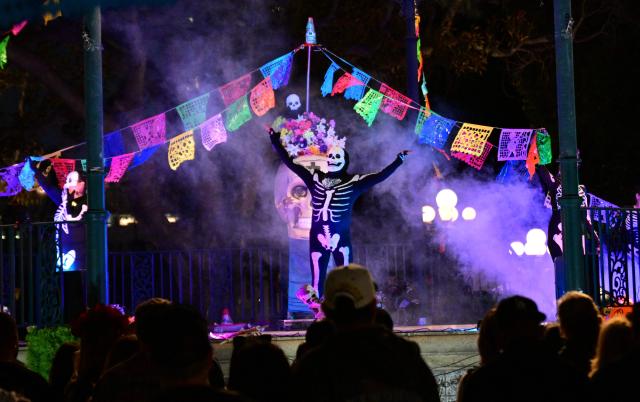 People watch a performance celebrating Dia de los Muertos (Day of the Dead) in Los Angeles, California, on October 30, 2026. Dia de los Muertos is a traditional Mexican celebration that honors and commemorates deceased loved ones. It emerged during the colonial period through the blending of Indigenous Mesoamerican traditions and rituals honoring the dead with Spanish Catholic observances of All Saints' Day and All Souls' Day. (Photo by Frederic J. BROWN / AFP)