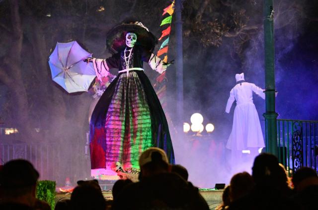 People watch a performance celebrating Dia de los Muertos (Day of the Dead) in Los Angeles, California, on October 30, 2026. Dia de los Muertos is a traditional Mexican celebration that honors and commemorates deceased loved ones. It emerged during the colonial period through the blending of Indigenous Mesoamerican traditions and rituals honoring the dead with Spanish Catholic observances of All Saints' Day and All Souls' Day. (Photo by Frederic J. BROWN / AFP)