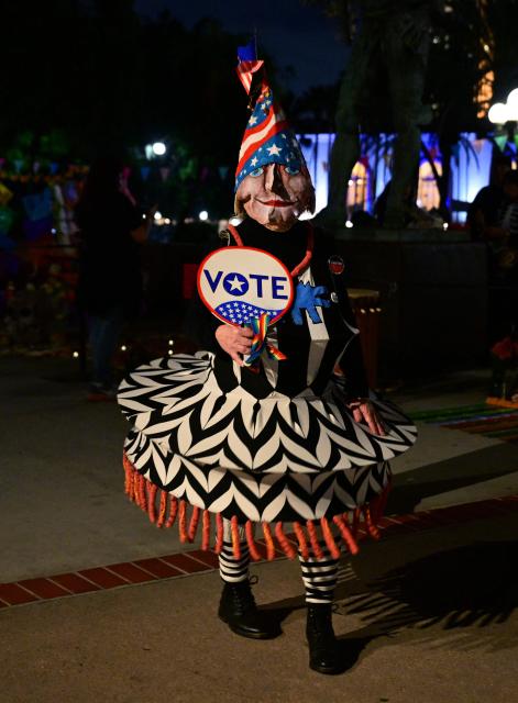 A performer celebrates Dia de los Muertos (Day of the Dead) in Los Angeles, California, on October 30, 2026. Dia de los Muertos is a traditional Mexican celebration that honors and commemorates deceased loved ones. It emerged during the colonial period through the blending of Indigenous Mesoamerican traditions and rituals honoring the dead with Spanish Catholic observances of All Saints' Day and All Souls' Day. (Photo by Frederic J. BROWN / AFP)