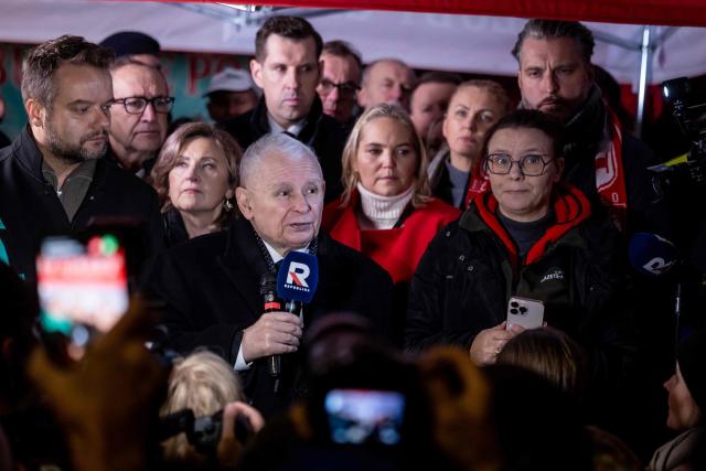 Poland's former Prime Minister and leader of the opposition Law and Justice (PiS) party, Jaroslaw Kaczynski (C) speaks as protesters gather outside the headquarters of Poland's Constitutional Court in Warsaw after police blocked access to the building on October 30, 2026. Poland's President Karol Nawrocki called off a visit to Africa in mid-flight as riot police deployed around the country's constitutional court on October 30 following the suspension of its chief justice in a battle between the centrist government and the nationalist right. Dozens of police guarded the entrance to the court as followers of the opposition right-wing Law and Justice party (PiS) protested the ousting of constitutional court president Bogdan Swieczkowski. (Photo by Wojtek RADWANSKI / AFP)