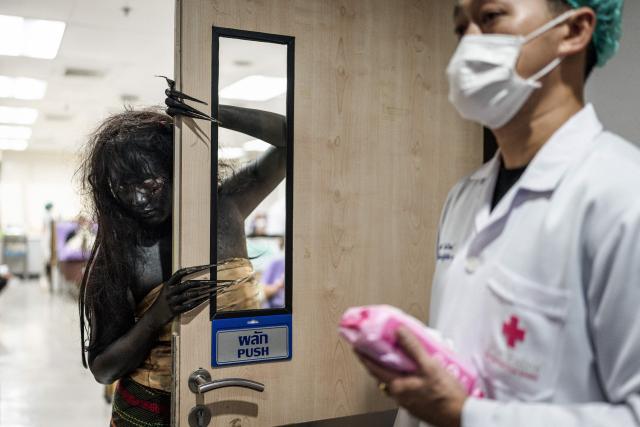 A Thai Red Cross staff member dressed in a Halloween costume (L) poses at the National Blood Center of the Thai Red Cross Society in Bangkok on October 31, 2026. (Photo by Chanakarn Laosarakham / AFP)