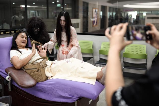 Thai Red Cross staff members dressed in Halloween costumes pose with a woman donating blood at the National Blood Center of the Thai Red Cross Society in Bangkok on October 31, 2026. (Photo by Chanakarn Laosarakham / AFP)