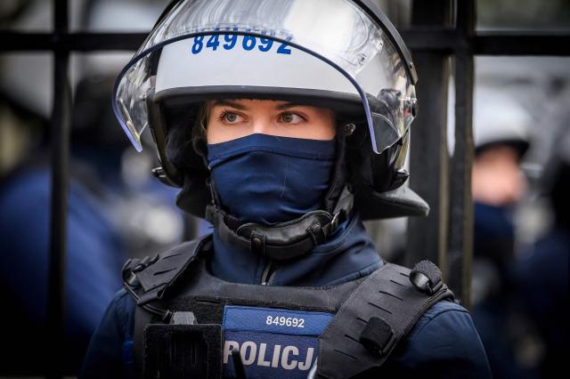 A police officer dressed in riot gear stands outside the headquarters of Poland's Constitutional Court as protesters gather in protest in Warsaw on October 31, 2026. Poland's President Karol Nawrocki called off a visit to Africa in mid-flight as riot police deployed around the country's constitutional court on October 30 following the suspension of its chief justice in a battle between the centrist government and the nationalist right. Dozens of police guarded the entrance to the court as followers of the opposition right-wing Law and Justice party (PiS) protested the ousting of constitutional court president Bogdan Swieczkowski. (Photo by Mladen ANTONOV / AFP)