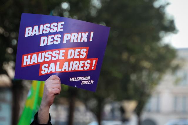 A protester holds a placard reading "price falls, wage rises" during a rally in Valenciennes, northern France on October 31, 2026, part of nationwide demonstrations over the rising cost of living and inequality organised by Yellow Vest movement, labour unions and high school and university students. "Exceptional" security deployment with 70,000 police officers and gendarmes mobilized and an alarmist tone: for Act III of the protests against the high cost of living, right in the middle of Halloween festivities, the authorities fear a repeat of the October 17 nightmare. France has been rocked by widespread anger over the rising cost of living and inequality. (Photo by Francois LO PRESTI / AFP)
