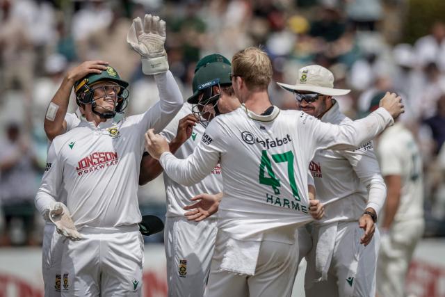 South Africa's Simon Harmer (C) is congratulated by teammates after the dismissal of Australia's Cooper Connolly on day five of the third Test match between South Africa and Australia at Newlands stadium in Cape Town on October 31, 2026. (Photo by Marco Longari / AFP)