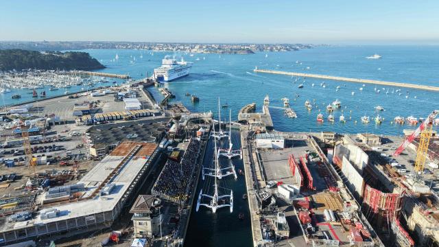 This aerial photograph shows multihulls leaving the harbour through the Naye lock of Saint-Malo's harbour, to moor of the coast of Saint-Malo northwestern France on October 31, 2026 a few days prior to the start of the Route du Rhum solo sailing race from Saint-Malo, to Pointe-a-Pitre in the French overseas island of Guadeloupe.  (Photo by LOU BENOIST / AFP)