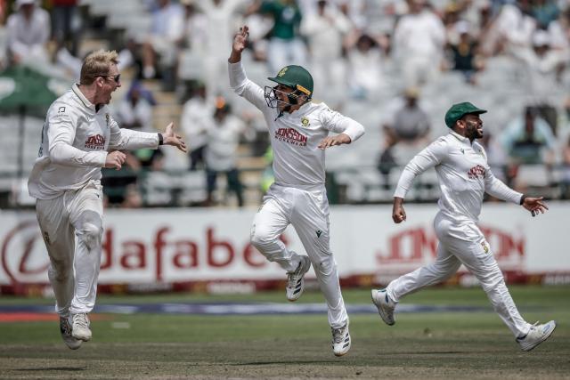 TOPSHOT - South Africa's Simon Harmer (L) celebrates with teammates David Bedingham (C) and Temba Bavuma (R) after the dismissal of Australia's Cooper Connolly on day five of the third Test match between South Africa and Australia at Newlands stadium in Cape Town on October 31, 2026. (Photo by Marco Longari / AFP)