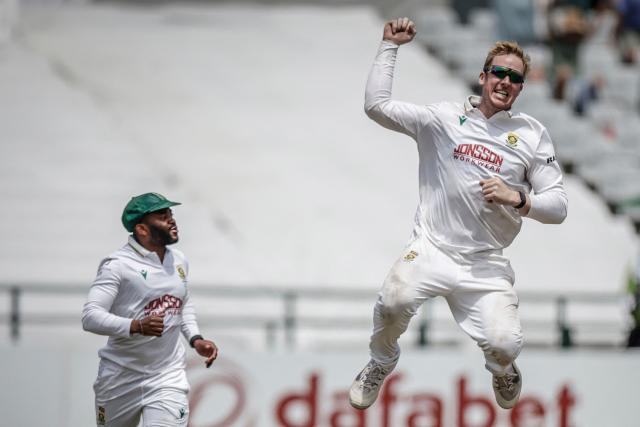 South Africa's Simon Harmer (R) jumps next to South Africa's Temba Bavuma (L) to celebrate the dismissal of Australia's Alex Carey on day five of the third Test match between South Africa and Australia at Newlands stadium in Cape Town on October 31, 2026. (Photo by Marco Longari / AFP) / ALTERNATIVE CROP