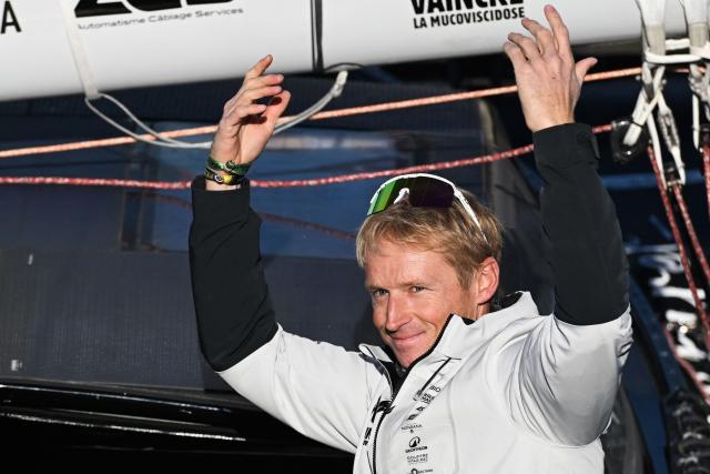French sailor Maxime Sorel reacts from aboard his "NC" IMOCA Class through the lock of Saint-Malo's harbour to moor off the coast of Saint-Malo, northwestern France on October 31, 2026 on the eve of the start of the Route du Rhum solo sailing race from Saint-Malo, to Pointe-a-Pitre in the French overseas island of Guadeloupe. (Photo by Sebastien Salom-Gomis / AFP)