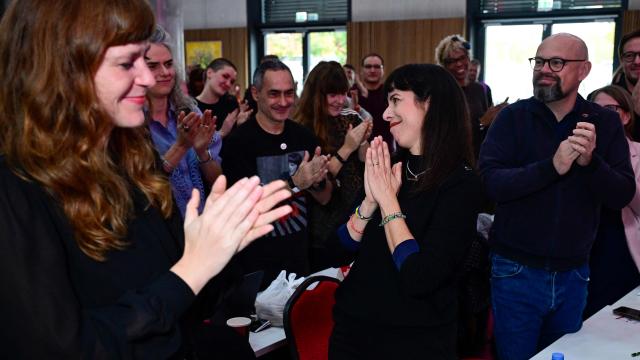 Elif Eralp, parliamentary group leader of the left-wing Die Linke party in Berlin's House of Representatives, (C) is applauded by delegates including chairwoman of the left-wing Die Linke party in Berlin Kerstin Wolter (L) and party member Tobias Schulze (R) during their extraordinary party convention on forming a government following elections in Berlin October 31, 2026. Germany's far-left Die Linke party scored a historic election win in Berlin in September 2026, but its path to power in the city-state has been complicated by its stance on the Israel-Palestinian conflict. Since its ballot box triumph, it has been accused of tolerating "Israel hate" and antisemitism in its ranks -- but also taken heat from members who say it is selling out its pro-Palestinian stance in pursuit of a governing coalition. (Photo by John MACDOUGALL / AFP)