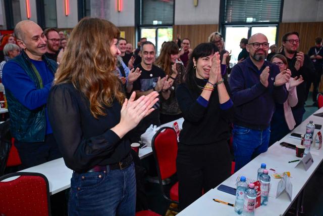 Elif Eralp, parliamentary group leader of the left-wing Die Linke party in Berlin's House of Representatives(C) reacts as she is praised by a speaker during their extraordinary party convention on forming a government following elections in Berlin October 31, 2026. Germany's far-left Die Linke party scored a historic election win in Berlin in September 2026, but its path to power in the city-state has been complicated by its stance on the Israel-Palestinian conflict. Since its ballot box triumph, it has been accused of tolerating "Israel hate" and antisemitism in its ranks -- but also taken heat from members who say it is selling out its pro-Palestinian stance in pursuit of a governing coalition. (Photo by John MACDOUGALL / AFP)
