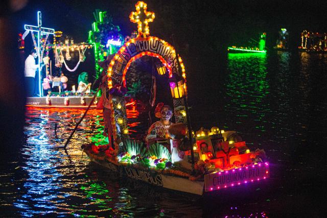 Locals sail small boats adorned with colorful flowers and lights as fishermen pay tribute to their deceased loved ones, as part of the Day of the Dead celebrations, in Sisal, Yucatan, Mexico, on October 30, 2026. (Photo by Hugo Borges / AFP)