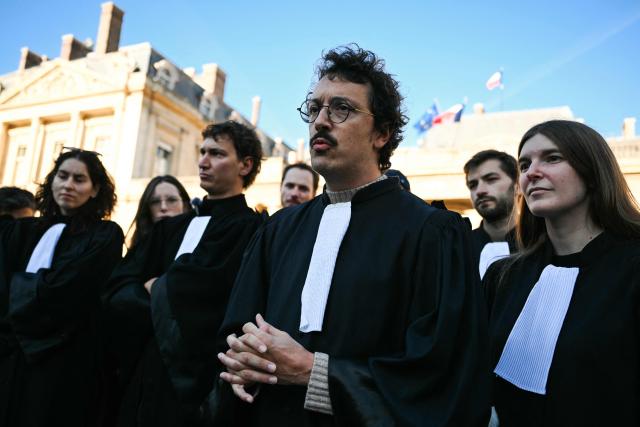 French lawyer and member of the collective "Colere Noire" Romain Ruiz speaks during a gathering of lawyers to protest against the State Council decision to maintain the ban on the Bastille-Nation route for the demonstration over the rising cost of living and inequality organised by Yellow Vest movement, labour unions and high school and university students, in front of the State Council, in Paris on October 31, 2026. In a final twist, the Paris procession will set off at 2:00 p.m. in the eastern part of the capital, following the decision by the Conseil d'État to overturn October 30s ruling by the Paris administrative court. (Photo by Martin LELIEVRE / AFP)