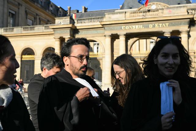 French lawyer and President of Paris' lawyers unions (SAF) Mohamed Jaite (C-L) looks on during a gathering of lawyers to protest against the State Council decision to maintain the ban on the Bastille-Nation route for the demonstration over the rising cost of living and inequality organised by Yellow Vest movement, labour unions and high school and university students, in front of the State Council, in Paris on October 31, 2026. In a final twist, the Paris procession will set off at 2:00 p.m. in the eastern part of the capital, following the decision by the Conseil d'État to overturn October 30s ruling by the Paris administrative court. (Photo by Martin LELIEVRE / AFP)