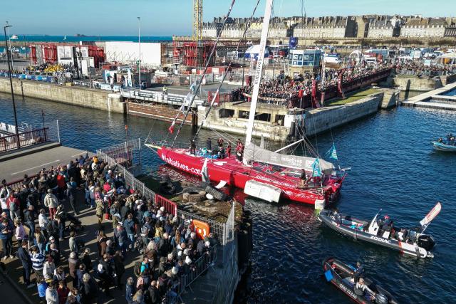 This aerial photograph shows skipper Violette Dorange sailing her Imoca Initiative Cњur  through the Naye lock of Saint-Malo's harbour, to moor off the coast of Saint-Malo northwestern France on October 31, 2026 on the eve of the start of the Route du Rhum solo sailing race from Saint-Malo, to Pointe-a-Pitre in the French overseas island of Guadeloupe. (Photo by LOU BENOIST / AFP)