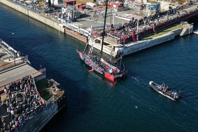 This aerial photograph shows skipper Jeremy Beyou sailing his Imoca Charal through the Naye lock of Saint-Malo's harbour, to moor off the coast of Saint-Malo northwestern France on October 31, 2026 on the eve of the start of the Route du Rhum solo sailing race from Saint-Malo, to Pointe-a-Pitre in the French overseas island of Guadeloupe. (Photo by LOU BENOIST / AFP)