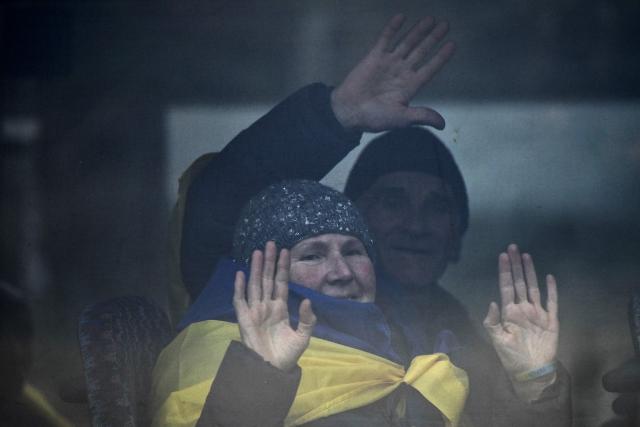 Residents evacuated from the Russian-controlled city of Oleshky during a humanitarian mission gesture sitting in a bus upon arriving at an undisclosed location in Ukraine on October 31, 2026, amid the Russian invasion of Ukraine. Residents of the Russian-controlled city of Oleshky, ravaged by years of war, arrived in Ukraine on October 31, 2026 after being evacuated via Belarus during a rare truce. (Photo by Genya SAVILOV / AFP)