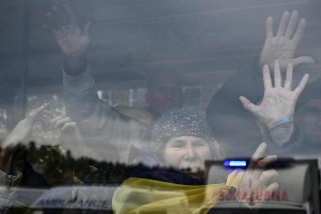 Residents evacuated from the Russian-controlled city of Oleshky during a humanitarian mission gesture next to a window sitting in a bus upon arriving at an undisclosed location in Ukraine on October 31, 2026, amid the Russian invasion of Ukraine. Residents of the Russian-controlled city of Oleshky, ravaged by years of war, arrived in Ukraine on October 31, 2026 after being evacuated via Belarus during a rare truce. (Photo by Genya SAVILOV / AFP)