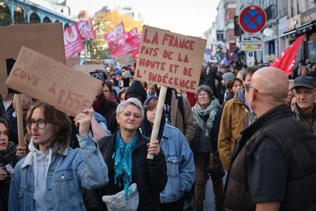 A protester holds a placard reading "France, a country of shame and indecency" during nationwide demonstrations over the rising cost of living and inequality organised by Yellow Vest movement, labour unions and high school and university students, in Lille, northern France on October 31, 2026. "Exceptional" security deployment with 70,000 police officers and gendarmes mobilized and an alarmist tone: for Act III of the protests against the high cost of living, right in the middle of Halloween festivities, the authorities fear a repeat of the October 17 nightmare. France has been rocked by widespread anger over the rising cost of living and inequality. (Photo by Francois LO PRESTI / AFP)