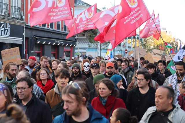 Protesters hold flags during nationwide demonstrations over the rising cost of living and inequality organised by Yellow Vest movement, labour unions and high school and university students, in Lille, northern France on October 31, 2026. "Exceptional" security deployment with 70,000 police officers and gendarmes mobilized and an alarmist tone: for Act III of the protests against the high cost of living, right in the middle of Halloween festivities, the authorities fear a repeat of the October 17 nightmare. France has been rocked by widespread anger over the rising cost of living and inequality. (Photo by Francois LO PRESTI / AFP)
