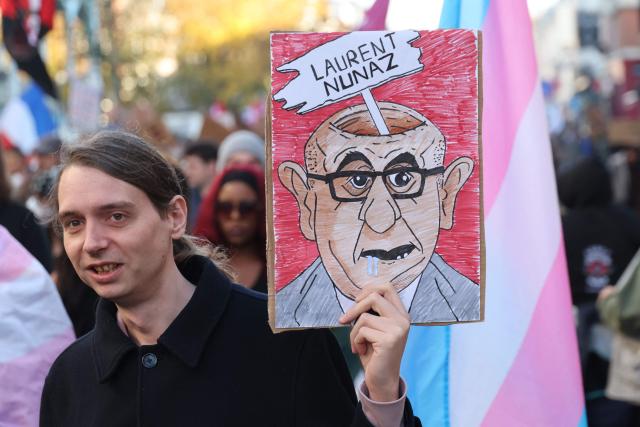 A protester holds a placard featuring a caricature of French Interior Minister Laurent Nunez, accompanied by a pun on his name, during nationwide demonstrations over the rising cost of living and inequality organised by Yellow Vest movement, labour unions and high school and university students, in Lille, northern France on October 31, 2026. "Exceptional" security deployment with 70,000 police officers and gendarmes mobilized and an alarmist tone: for Act III of the protests against the high cost of living, right in the middle of Halloween festivities, the authorities fear a repeat of the October 17 nightmare. France has been rocked by widespread anger over the rising cost of living and inequality. (Photo by Francois LO PRESTI / AFP)
