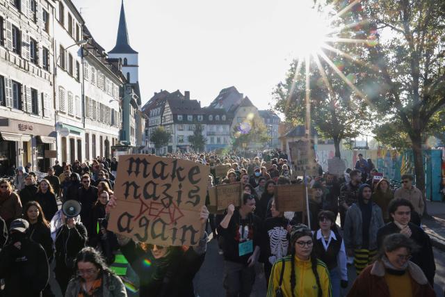 Protestors hold signs during nationwide demonstrations over the rising cost of living and inequality organised by Yellow Vest movement, labour unions and high school and university students, in Strasbourg, eastern France on October 31, 2026. "Exceptional" security deployment with 70,000 police officers and gendarmes mobilized and an alarmist tone: for Act III of the protests against the high cost of living, right in the middle of Halloween festivities, the authorities fear a repeat of the October 17 nightmare. France has been rocked by widespread anger over the rising cost of living and inequality. (Photo by ROMEO BOETZLE / AFP)