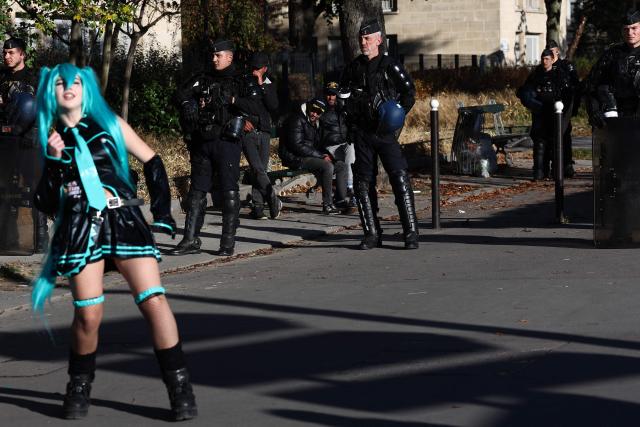 A protester dressed up as a Comicon character dances in front of French Gendarmes during a protest march as part of nationwide demonstrations over the rising cost of living and inequality organised by Yellow Vest movement, labour unions and high school and university students, in Paris on October 31, 2026. "Exceptional" security deployment with 70,000 police officers and gendarmes mobilized and an alarmist tone: for Act III of the protests against the high cost of living, right in the middle of Halloween festivities, the authorities fear a repeat of the October 17 nightmare. France has been rocked by widespread anger over the rising cost of living and inequality. (Photo by Sameer AL-DOUMY / AFP)