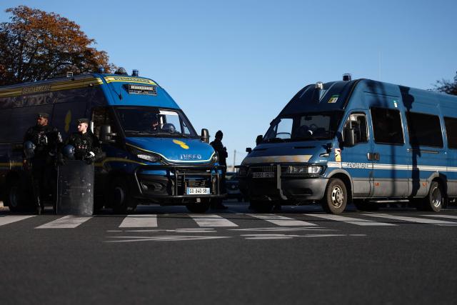 French Gendarmes stand guard by their vehicles in the street during a protest march part of nationwide demonstrations over the rising cost of living and inequality organised by Yellow Vest movement, labour unions and high school and university students, in Paris on October 31, 2026. "Exceptional" security deployment with 70,000 police officers and gendarmes mobilized and an alarmist tone: for Act III of the protests against the high cost of living, right in the middle of Halloween festivities, the authorities fear a repeat of the October 17 nightmare. France has been rocked by widespread anger over the rising cost of living and inequality. (Photo by Sameer AL-DOUMY / AFP)