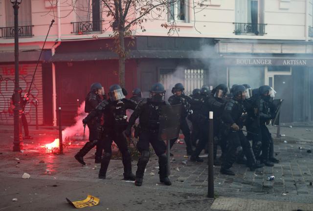French police officers face protesters at the end of a protest march during nationwide demonstrations over the rising cost of living and inequality organised by Yellow Vest movement, labour unions and high school and university students, in Paris on October 31, 2026. "Exceptional" security deployment with 70,000 police officers and gendarmes mobilized and an alarmist tone: for Act III of the protests against the high cost of living, right in the middle of Halloween festivities, the authorities fear a repeat of the October 17 nightmare. France has been rocked by widespread anger over the rising cost of living and inequality. (Photo by Sameer AL-DOUMY / AFP)