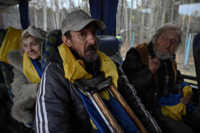 Valery (R), 66, Igor (C), 49, and Svitlana (L), 90, evacuated from the Russian-controlled city of Oleshky during a humanitarian mission sit in a bus upon their arrival at an undisclosed location in Ukraine on October 31, 2026, amid the Russian invasion of Ukraine. Residents of the Russian-controlled city of Oleshky, ravaged by years of war, arrived in Ukraine on October 31, 2026 after being evacuated via Belarus during a rare truce brokered by US First Lady Melania Trump. (Photo by Genya SAVILOV / AFP)